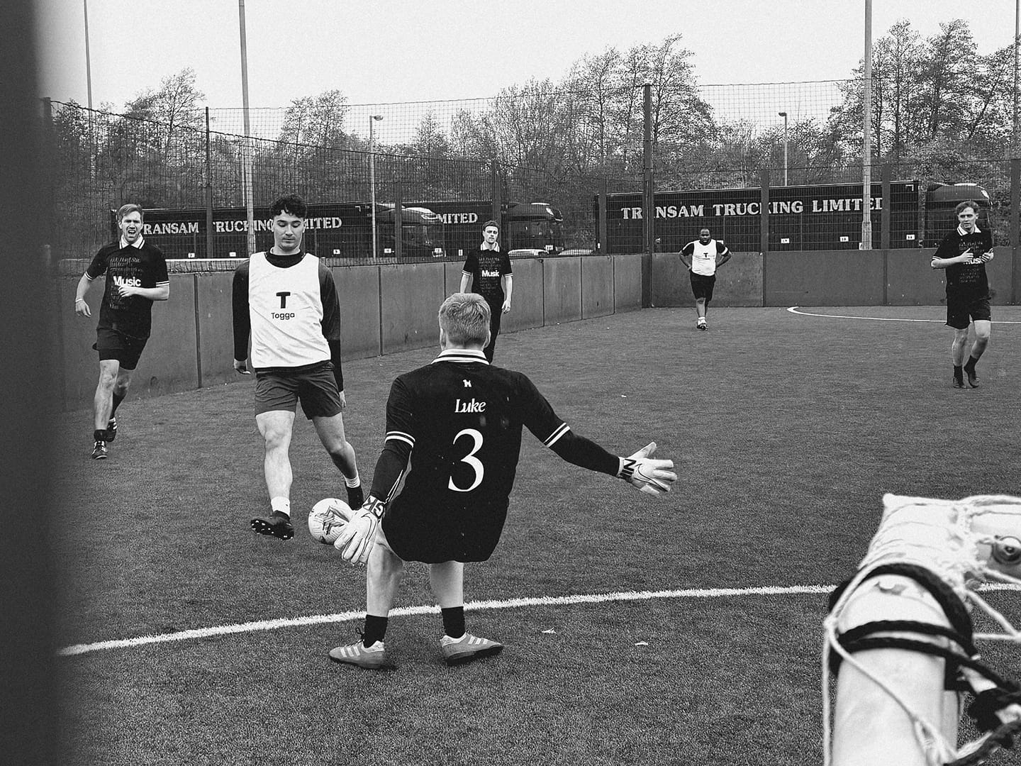 Photograph from Cup North 25. A player is shooting from outside the 5-a-side D with the goalkeeper closing him down.