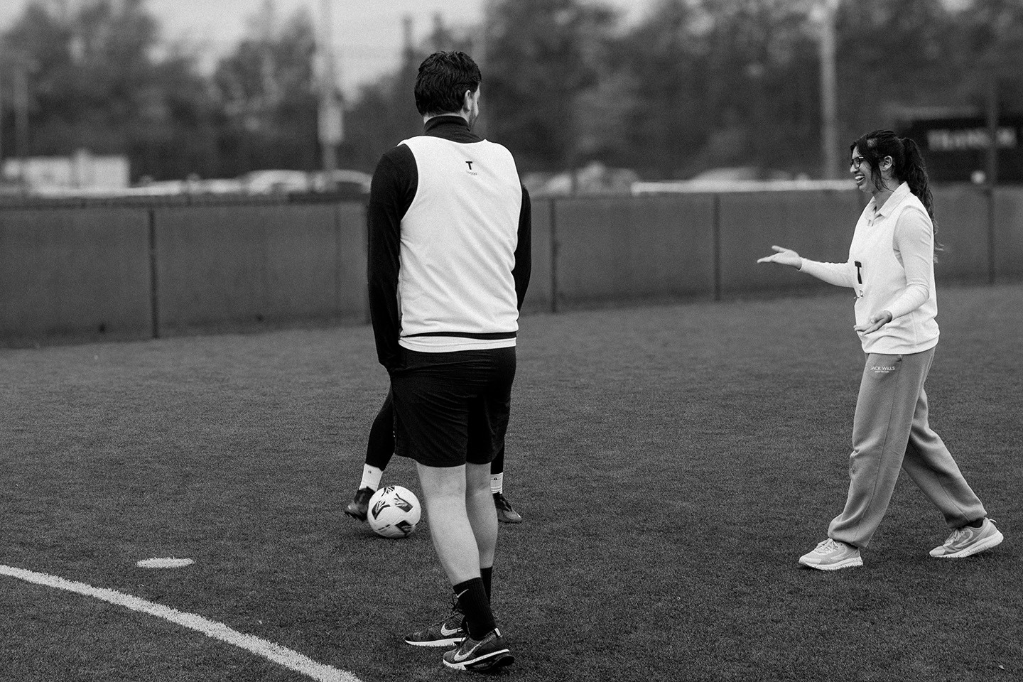 Photograph from Cup North 25. Players on the pitch sharing a joke.