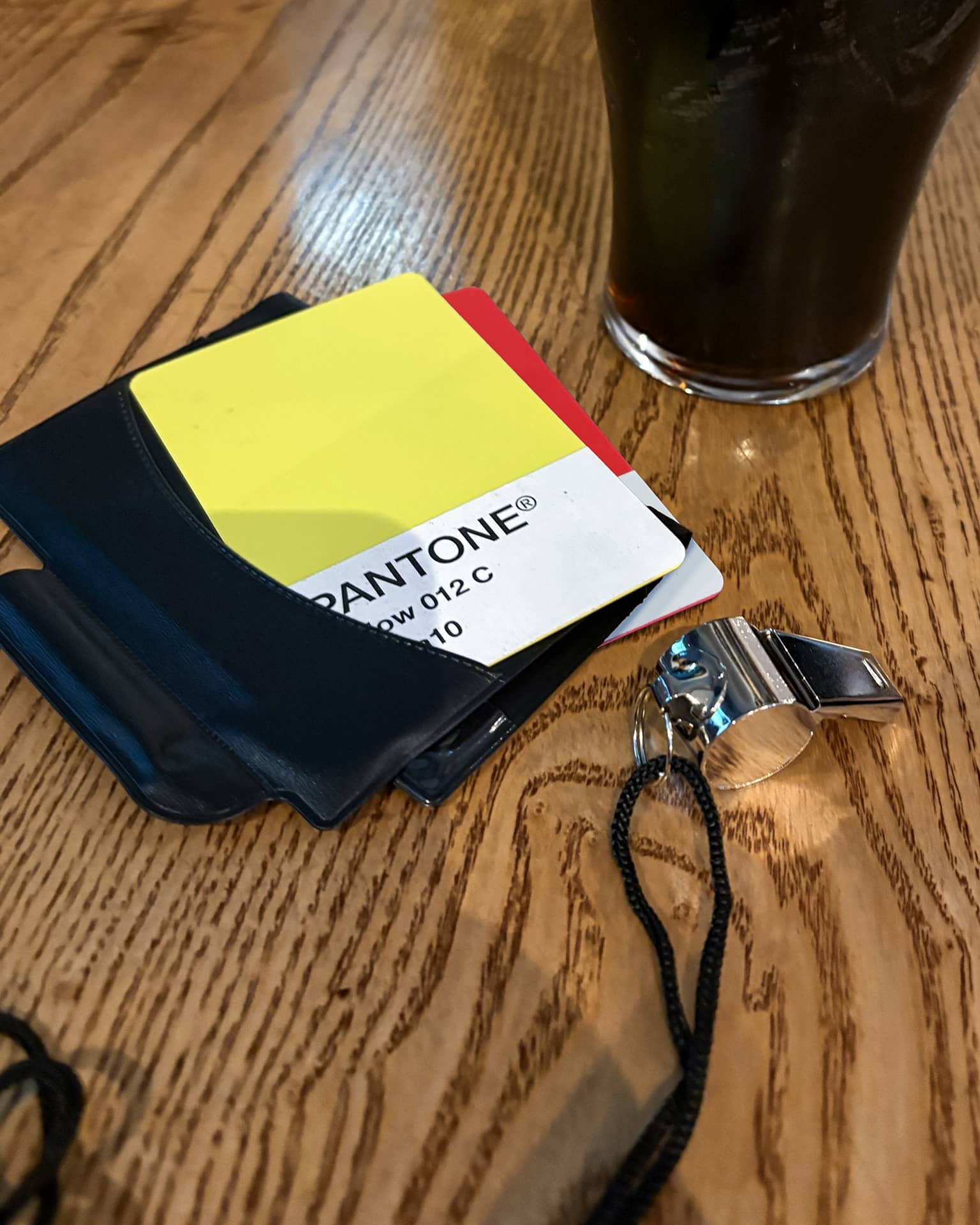 Photograph from Cup North 25. Post match scene in the pub with a yellow and red card styled like a Pantone colour swatch.